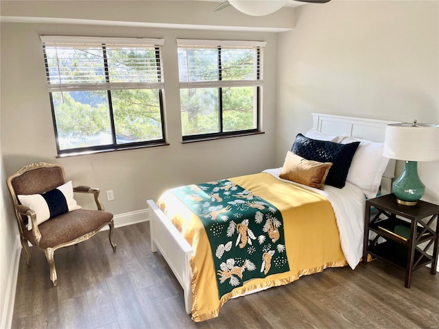 bedroom with multiple windows, dark wood-type flooring, and ceiling fan