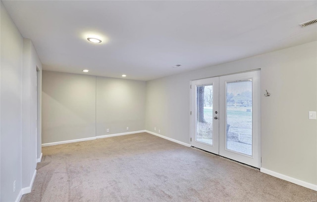 carpeted spare room featuring french doors