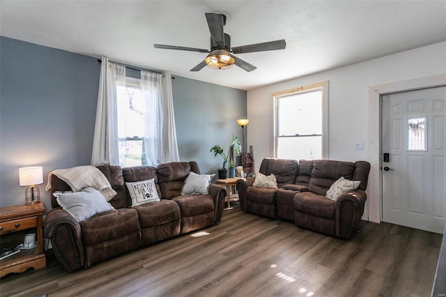 living room with ceiling fan and dark wood-type flooring