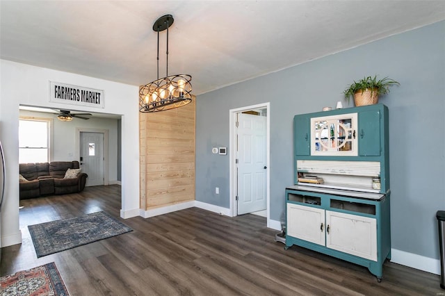 unfurnished dining area featuring ceiling fan and dark wood-type flooring