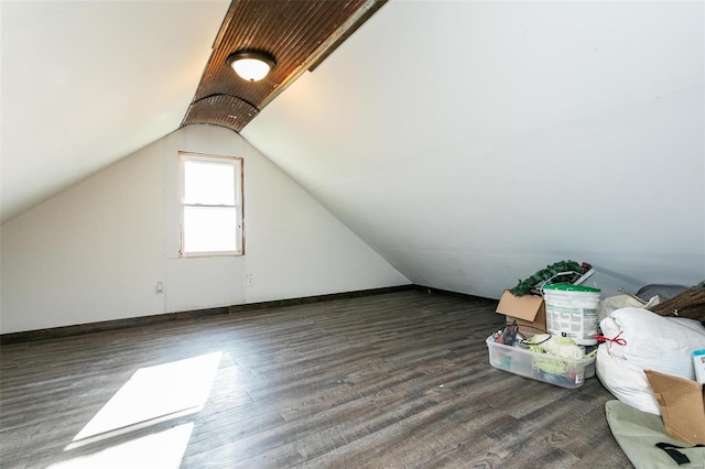 bonus room with dark hardwood / wood-style floors and vaulted ceiling