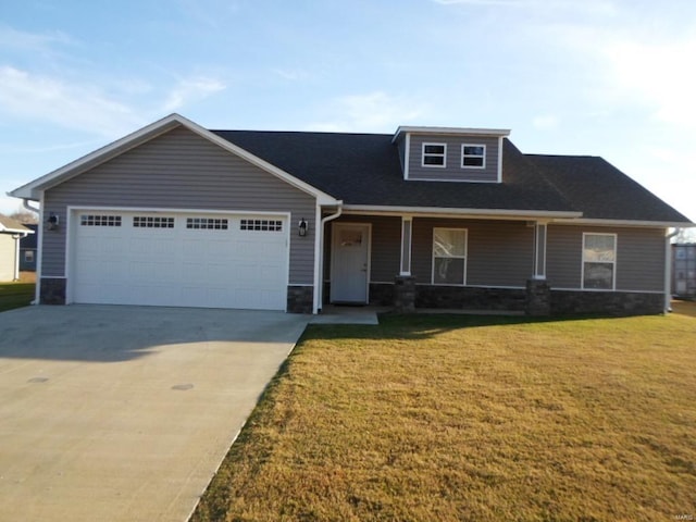 view of front of property featuring a front lawn, covered porch, and a garage