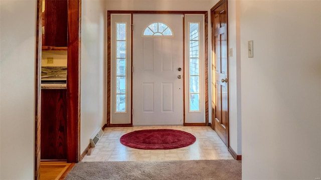 foyer entrance featuring light carpet