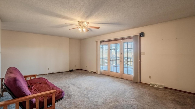 sitting room featuring carpet, a textured ceiling, and ceiling fan