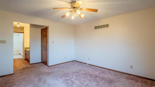 carpeted empty room featuring a textured ceiling and ceiling fan