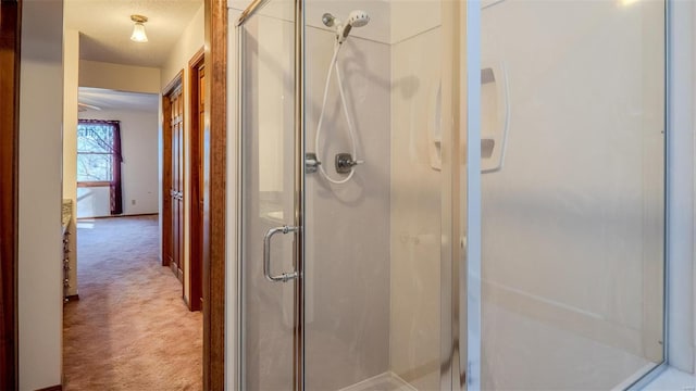 bathroom featuring a shower with door and a textured ceiling