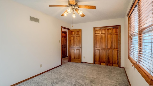 unfurnished bedroom featuring carpet, a textured ceiling, a closet, and ceiling fan