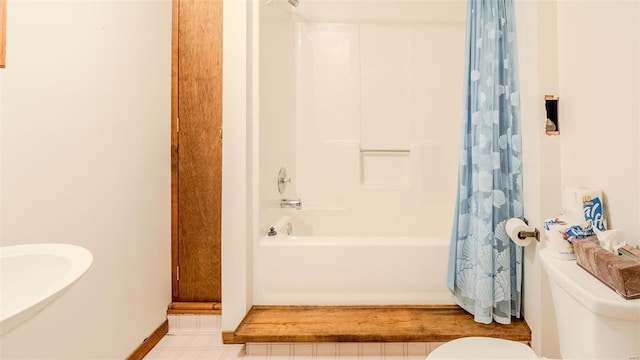 bathroom featuring shower / tub combo and toilet