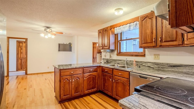 kitchen featuring ceiling fan, light hardwood / wood-style floors, kitchen peninsula, and a textured ceiling