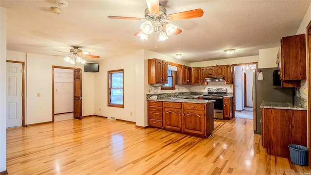 kitchen with sink, light wood-type flooring, a textured ceiling, and appliances with stainless steel finishes