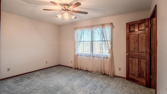 carpeted spare room with ceiling fan and a textured ceiling