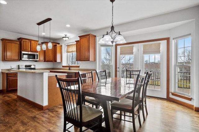 dining space with dark wood finished floors, an inviting chandelier, recessed lighting, and baseboards