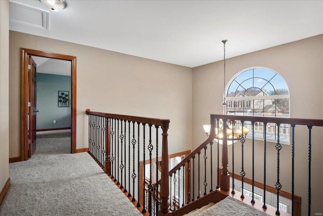 stairs featuring a notable chandelier, baseboards, and carpet floors