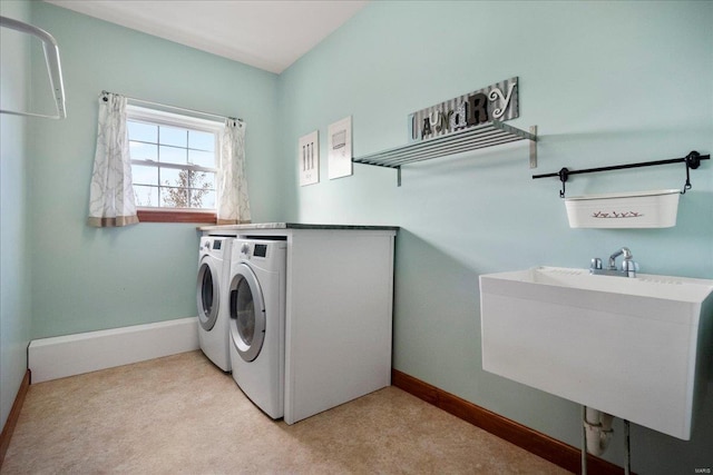 washroom with laundry area, washing machine and dryer, baseboards, and a sink