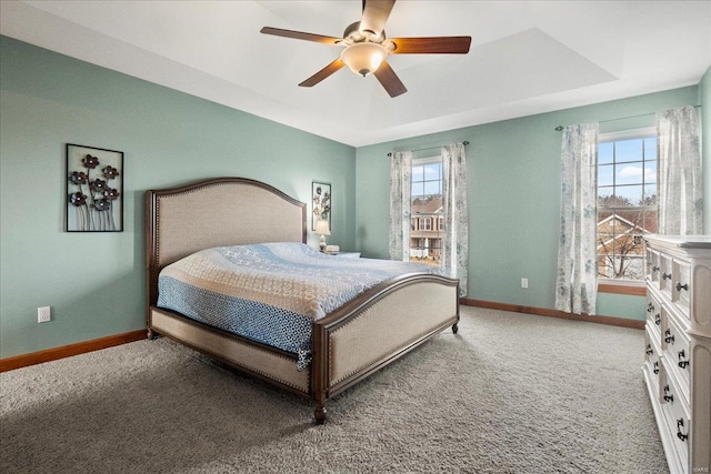 bedroom featuring baseboards, a raised ceiling, and carpet floors