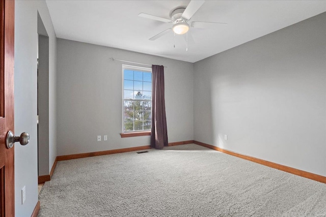 carpeted empty room with visible vents, baseboards, and ceiling fan