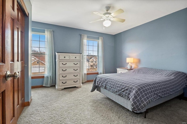 bedroom featuring a ceiling fan, baseboards, and light carpet