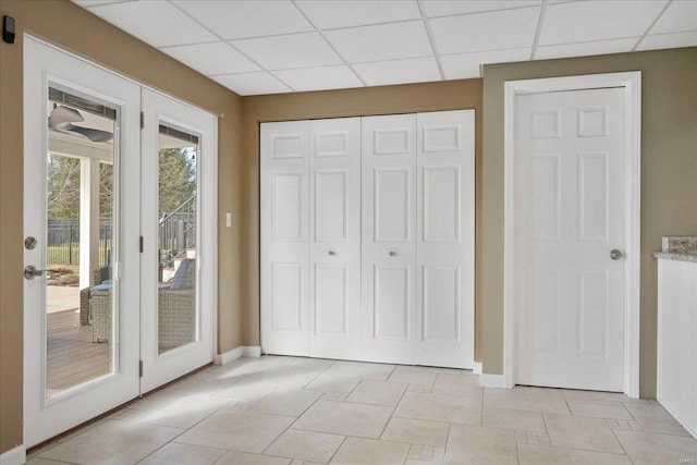 unfurnished bedroom featuring a closet, a drop ceiling, baseboards, and access to outside