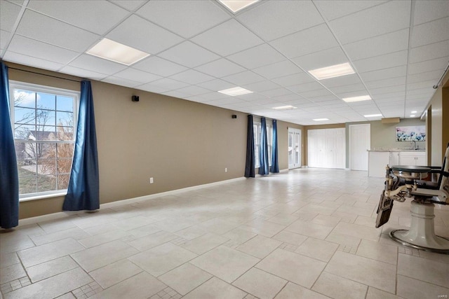 interior space featuring baseboards and a drop ceiling