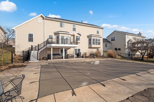 rear view of house with a fenced in pool, stairs, a patio, and fence