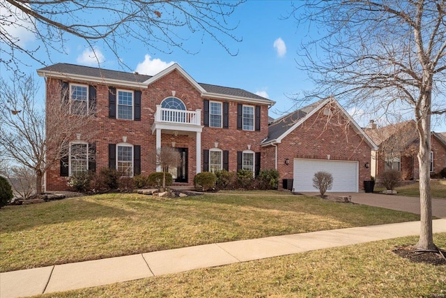 view of front of home with a front lawn, a balcony, concrete driveway, an attached garage, and brick siding