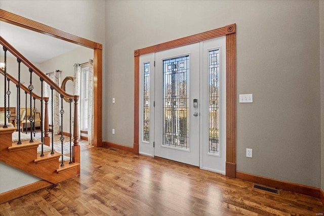 foyer featuring visible vents, baseboards, and wood finished floors