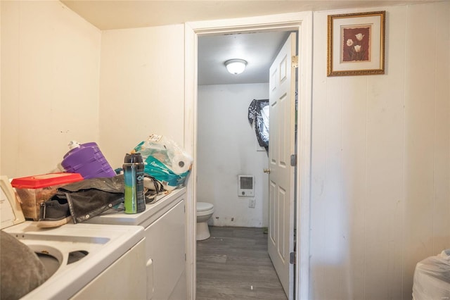 washroom featuring heating unit, washer and clothes dryer, and dark wood-type flooring