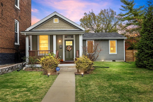 bungalow-style house with covered porch and a yard