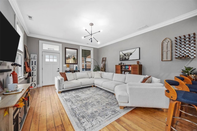 living room with a chandelier, wood-type flooring, and crown molding