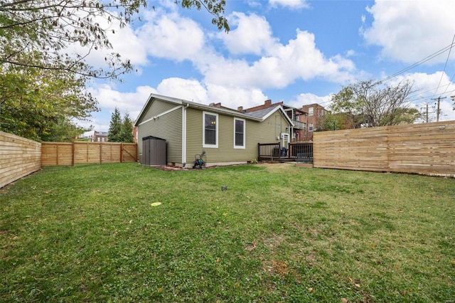 back of property featuring a storage unit, a lawn, and a fenced backyard