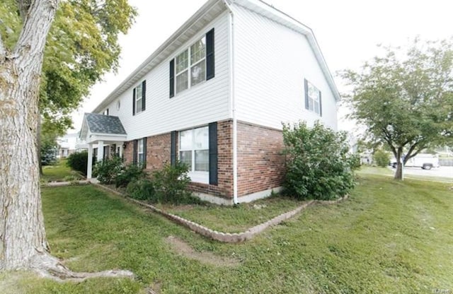 view of side of home with a yard