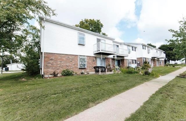 exterior space featuring a lawn and a balcony