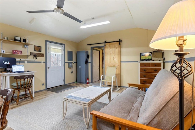 living room featuring a barn door, ceiling fan, light hardwood / wood-style floors, and vaulted ceiling