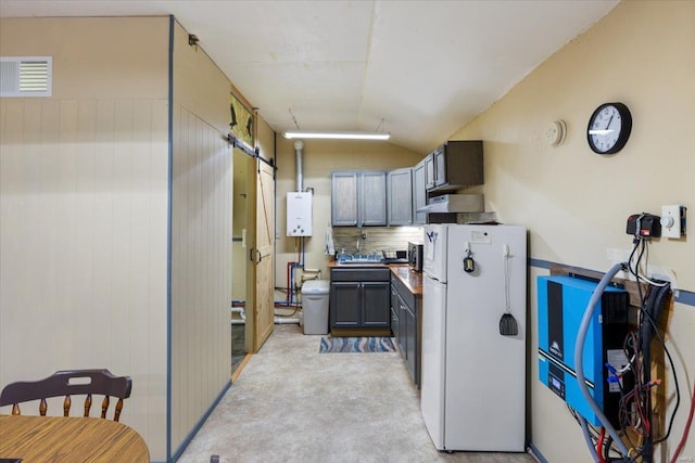 kitchen featuring gray cabinetry, light carpet, white refrigerator, vaulted ceiling, and decorative backsplash