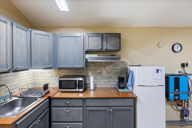 kitchen featuring gray cabinetry, wall chimney exhaust hood, white refrigerator, and sink