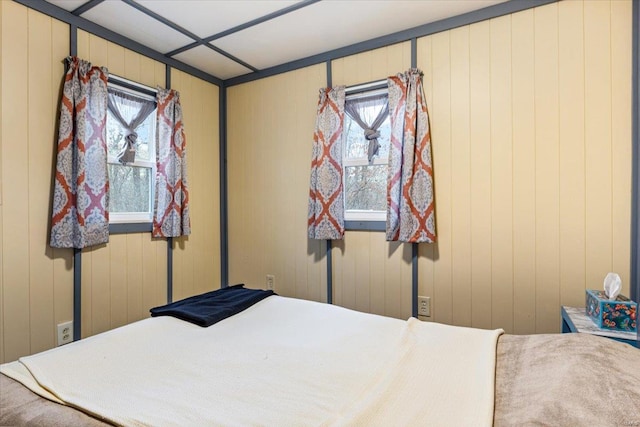 bedroom featuring wooden walls