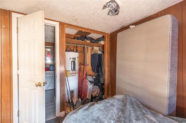 bedroom featuring a closet, electric water heater, and a textured ceiling