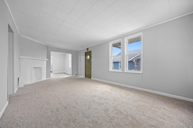 unfurnished living room with carpet flooring, a fireplace, and crown molding