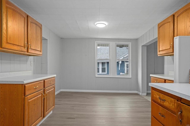 kitchen featuring wood walls and light hardwood / wood-style flooring