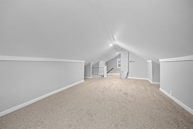 additional living space featuring carpet floors and vaulted ceiling