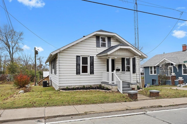 bungalow with a front yard, a porch, and cooling unit