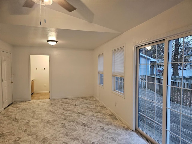 empty room with ceiling fan and vaulted ceiling