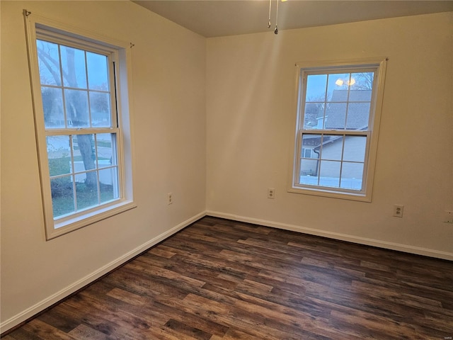 spare room featuring ceiling fan, plenty of natural light, and dark wood-type flooring