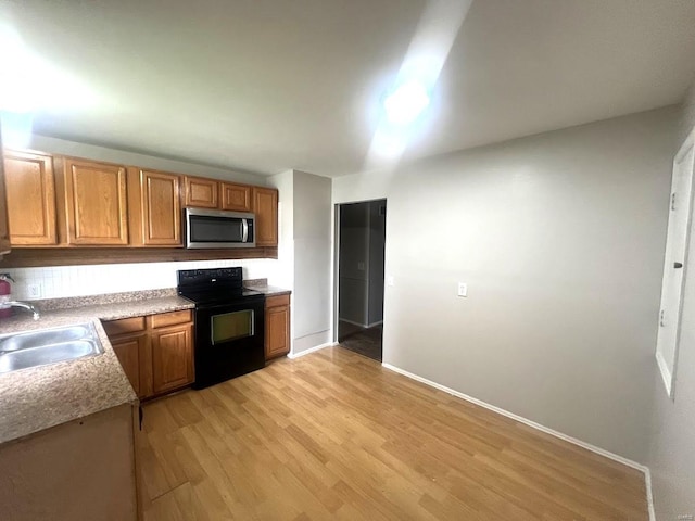 kitchen with black range with electric stovetop, sink, and light wood-type flooring