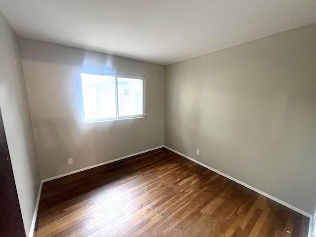 spare room featuring dark wood-type flooring