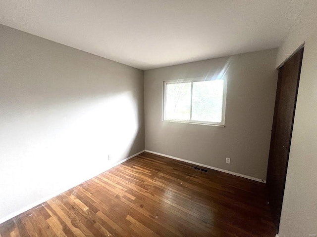 empty room featuring dark hardwood / wood-style flooring