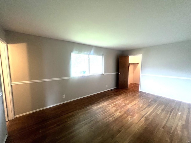 unfurnished bedroom with a closet and dark wood-type flooring