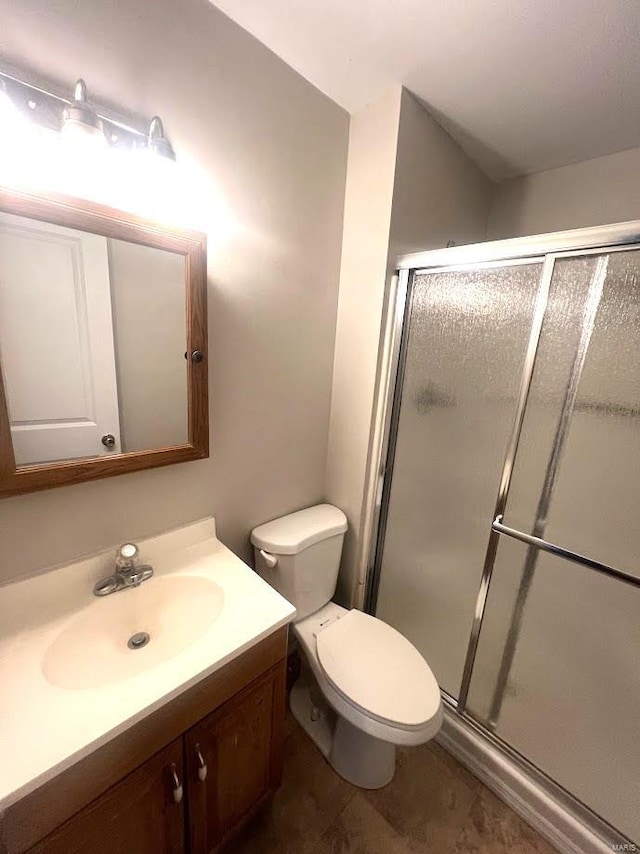 bathroom featuring vanity, an enclosed shower, and toilet