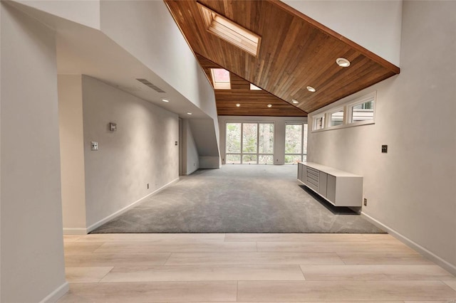 hall with light colored carpet, high vaulted ceiling, and wooden ceiling