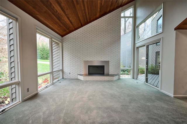 unfurnished living room featuring carpet, wood ceiling, high vaulted ceiling, and a brick fireplace